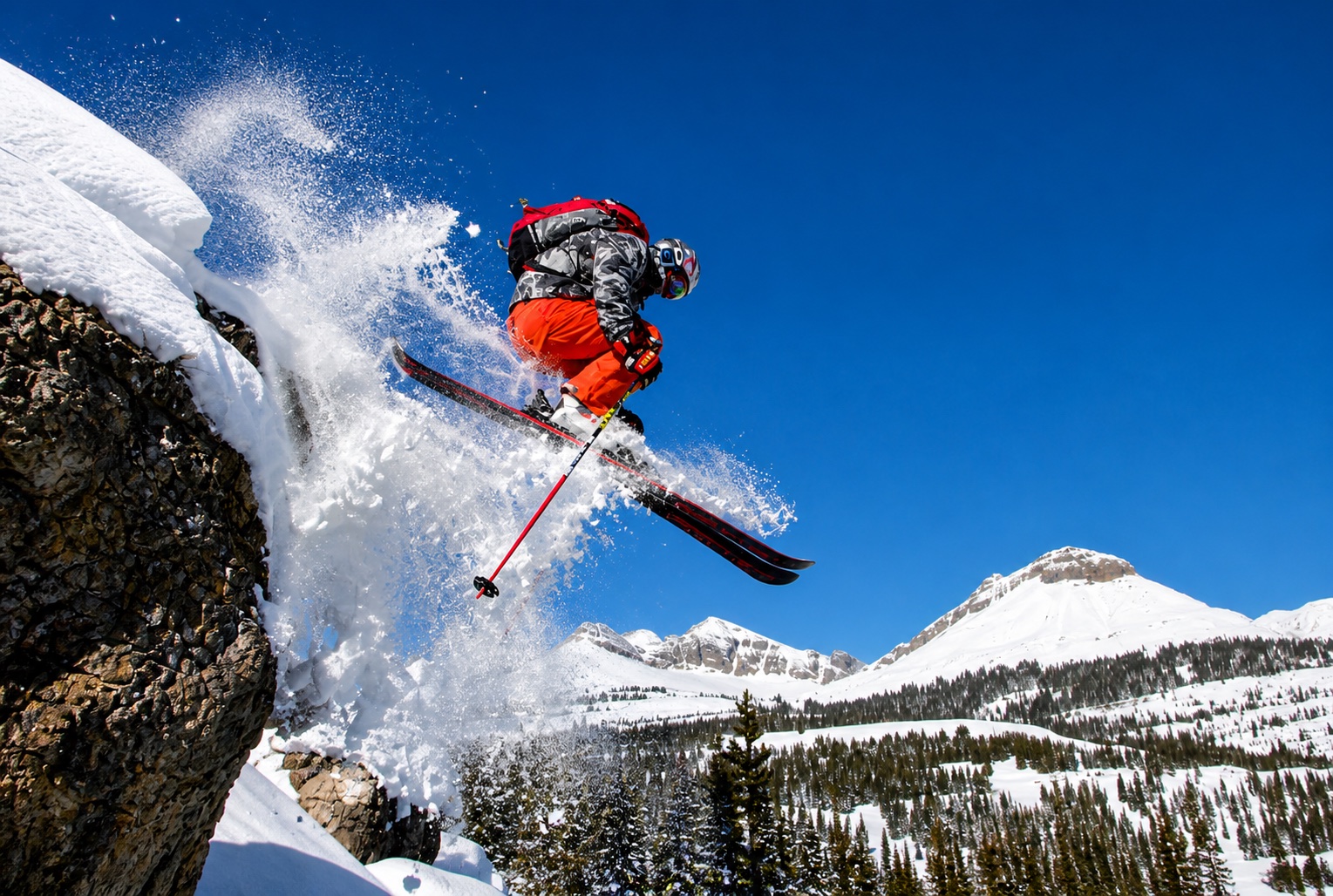 Freeride skier jumping from a snowy ridge